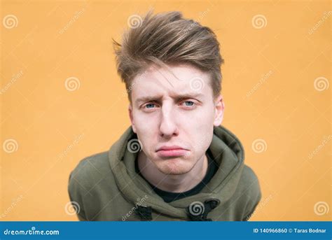 Portrait of a Sad Young Man on an Orange Background. Funny Guy on a ...