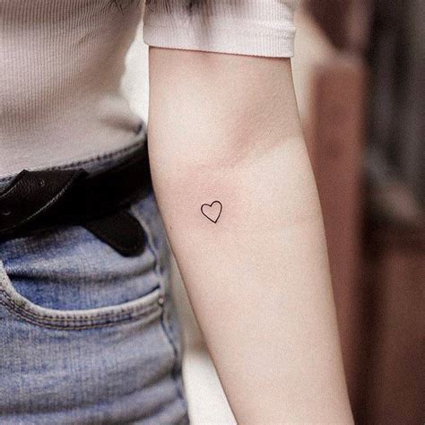 Minimalist heart tattoo on the inner forearm.