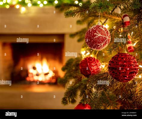 Christmas tree, burning fireplace background. Warm cozy Xmas holiday home. Christmas bauble ...