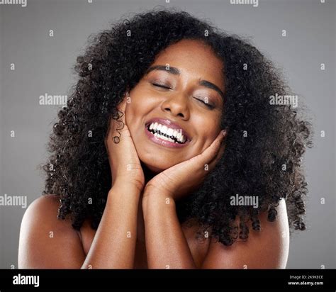 Black woman, skincare model with smile in studio against grey wall background with happiness ...