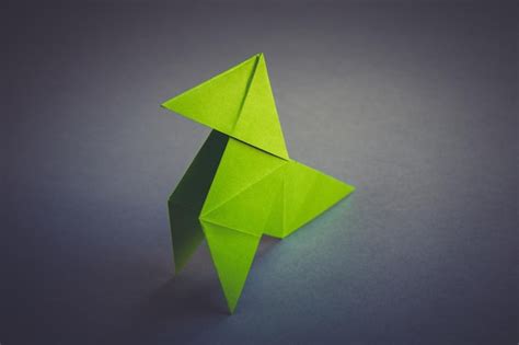 Premium Photo | Green paper hen origami isolated on a grey background