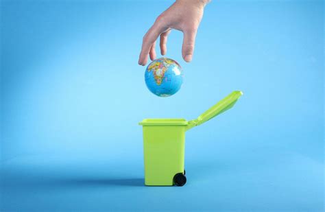 Hand throwing globe into trash can - Creative Commons Bilder