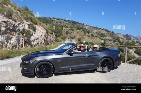 Man and woman driving Ford Mustang 5 Litre V8 convertable with open top Stock Photo - Alamy