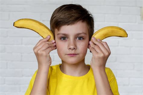 Funny Face. Banana As Horns. Young Boy in Yellow T-shirt Holding Banana ...