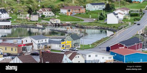 Small village community, Twillingate, Newfoundland. Fishing boats docked along the shoreline in ...