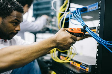 Crop focused ethnic engineer using electric screwdriver · Free Stock Photo