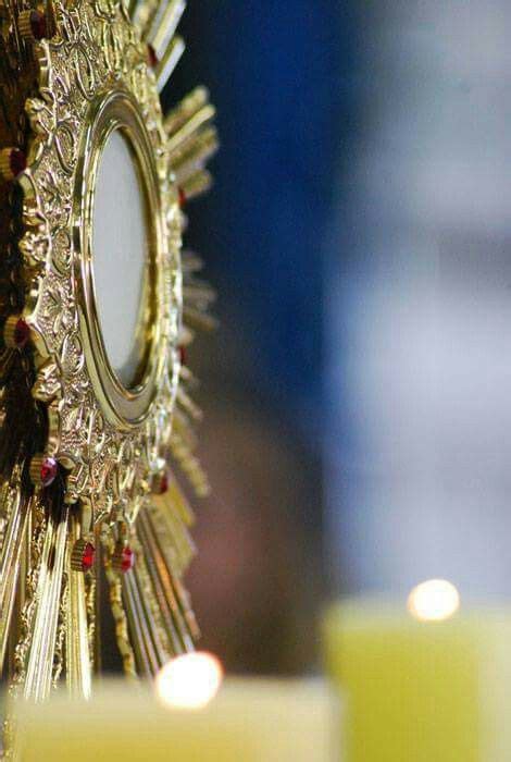 a close up view of a cross with candles in the background