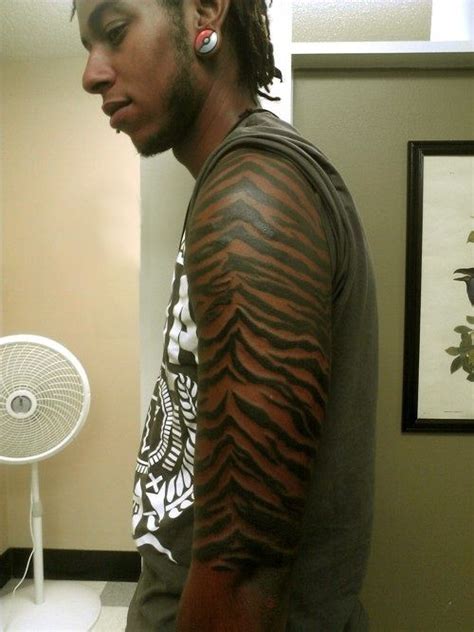 very interesting tiger skin tattoo. I think it would look much better on lighter skin; he should ...