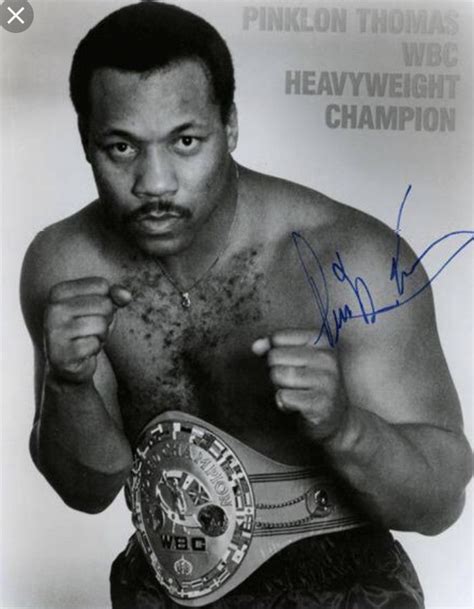 an autographed photograph of a man holding a boxing belt in his right hand