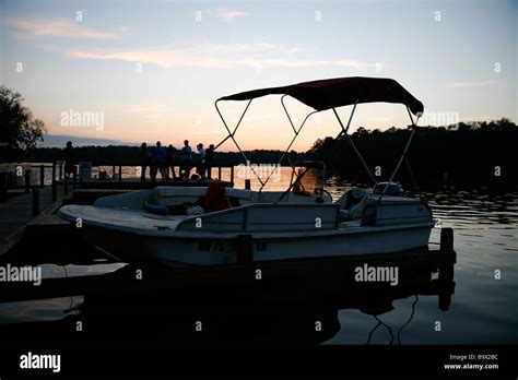 Boat on lake at sunset Stock Photo - Alamy