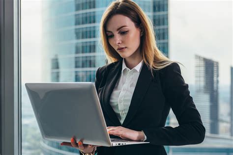 Young female lawyer working in her luxurious office holding a laptop ...