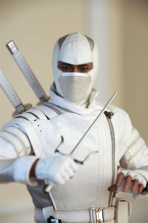 a man dressed in white holding two swords