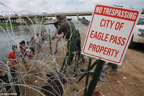 Eagle Pass border standoff: Texas National Guard stare into the eyes of migrants just feet away ...