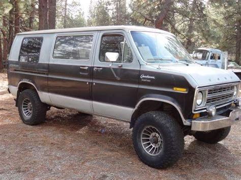 a black and silver van parked in the woods