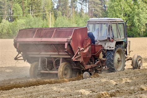 Premium Photo | Potato planter attached to farm tractor planting ...