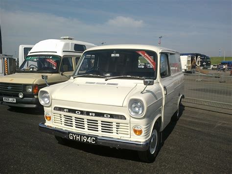 two vans parked next to each other in a parking lot