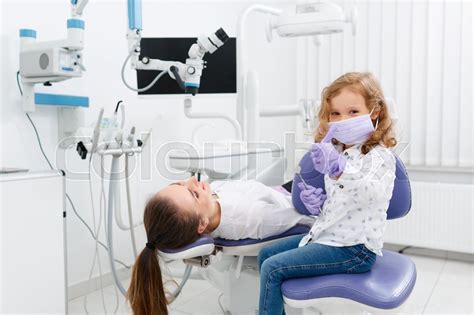 Cute little girl playing dentist ... | Stock image | Colourbox