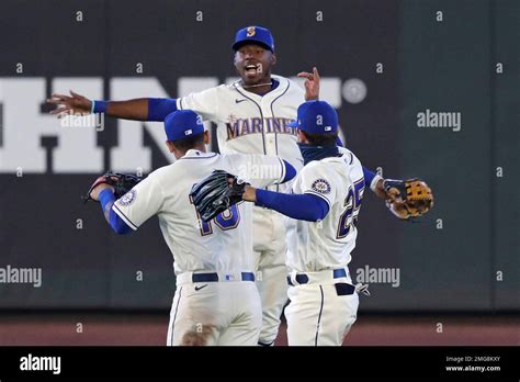 Seattle Mariners outfielders Kyle Lewis, center, Tim Lopes (10) and ...