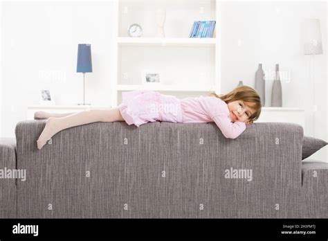 Little girl lying on couch Stock Photo - Alamy