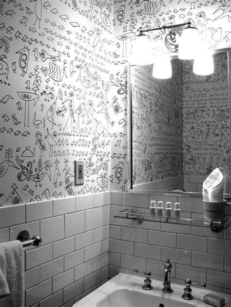 a bathroom with a sink, mirror and writing on the wall behind it in black and white