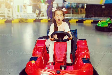 Little girl driving toy red car 22191288 Stock Photo at Vecteezy