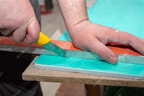 Premium Photo | Male hands measure and cut drywall sandwich panel with a construction knife ...