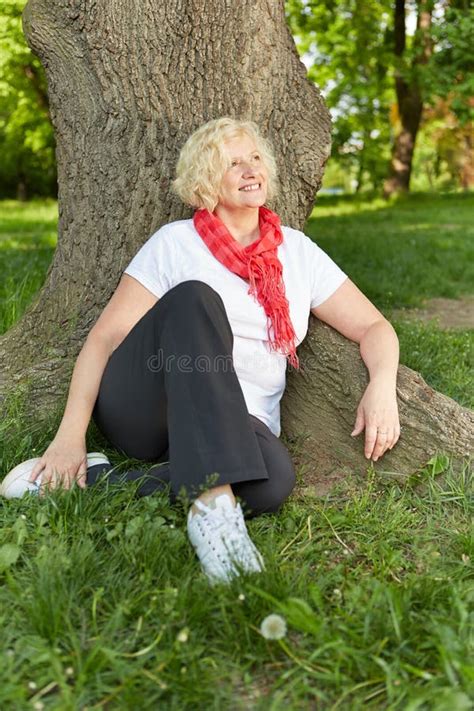 Senior Woman Sitting at a Tree in a Garden Stock Photo - Image of outdoors, retiree: 61452800