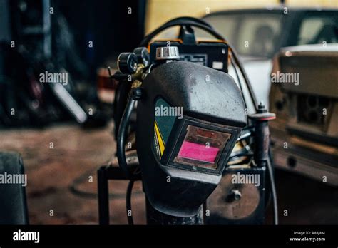 Welding mask on garage workshop background Stock Photo - Alamy