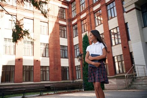 Premium Photo | Orange colored building school girl in uniform is outdoors