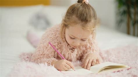 Adorable Blonde Girl Drawing on Notebook Lying on Bed at Bedroom Stock Photo - Image of pillow ...