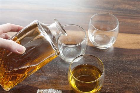 Man pouring tumblers of whiskey - Free Stock Image