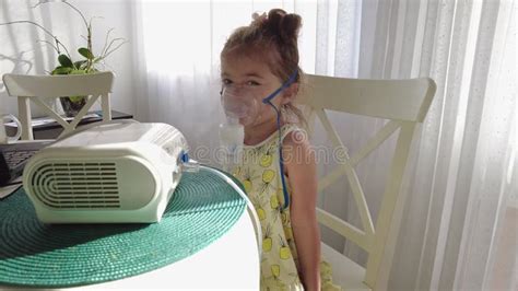 Cute Little Girl in the Mask of an Inhaler. Procedure of Inhalation at Home. Kid Taking ...