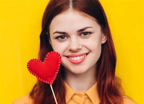 Premium Photo | Portrait of young woman holding heart shape against ...