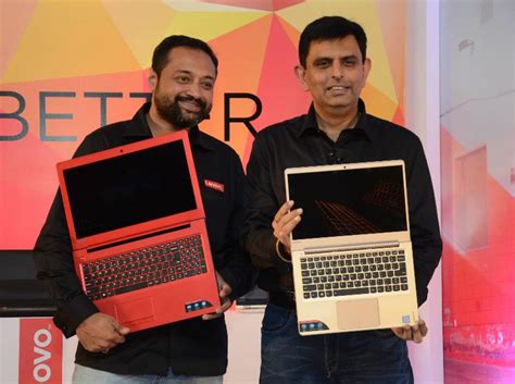 two men holding up laptops in their hands