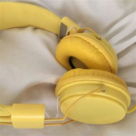 a pair of yellow headphones laying on top of a white sheet