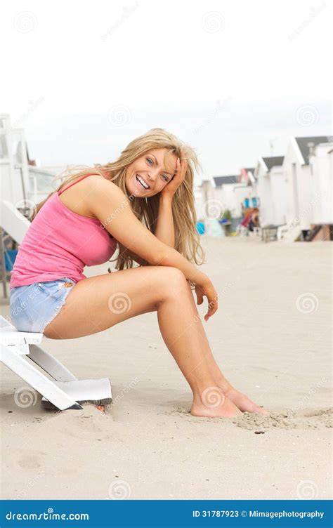 Beautiful Young Woman Sitting At The Beach And Laughing Stock Photos - Image: 31787923