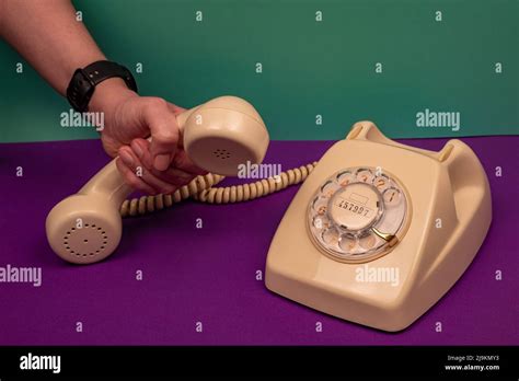 Woman's hand picking up an old phone Stock Photo - Alamy