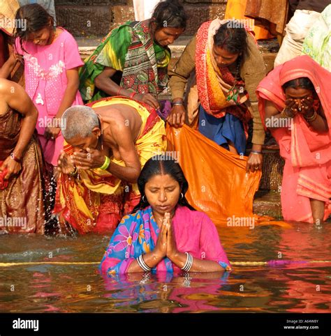 People bathing and praying at the river Ganges on the ghats in Varanasi ...