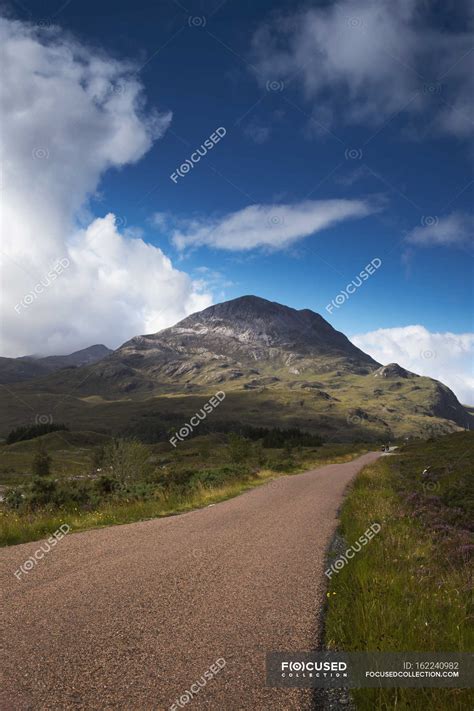 Gravel road through rugged landscape — background, remote - Stock Photo ...