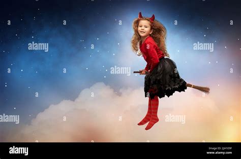 girl in halloween costume flying on witch's broom Stock Photo - Alamy