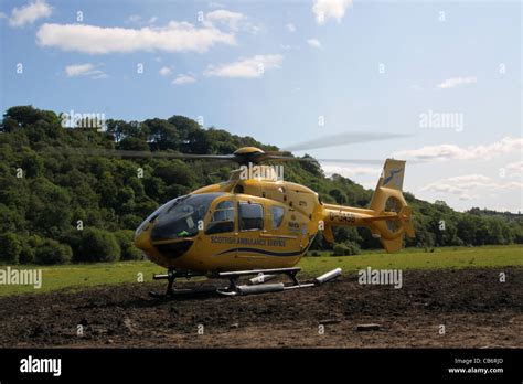 Scottish Ambulance Service air ambulance helicopter preparing and taking off from field after ...