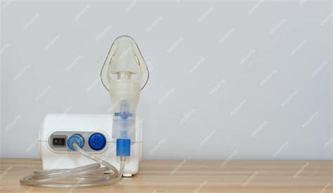 Premium Photo | The nebulizer for inhalation stands on a table against ...