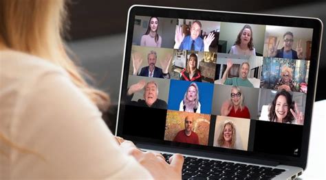 a woman sitting in front of a laptop computer with many people on it's screen