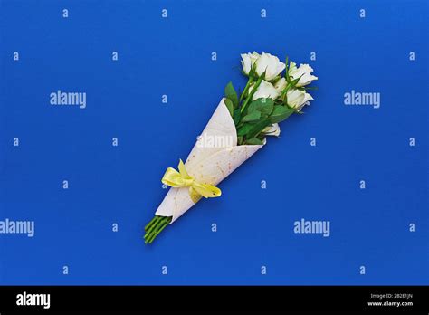 Bouquet of white roses wrapped in tortilla on classic blue background. Concept of edible, zero ...