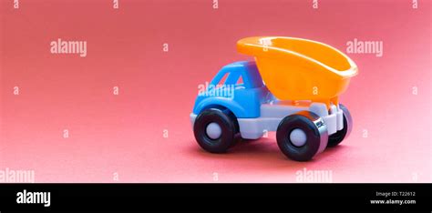 Colorful toy truck on a pink background, side view Stock Photo - Alamy