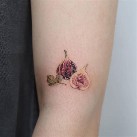 Micro-realistic tattoo of a fig done on the upper arm.