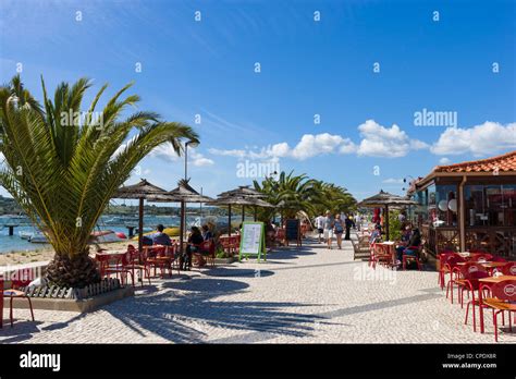 Seafront restaurants by the harbour in the resort of Alvor, near Portimao, Algarve, Portugal ...