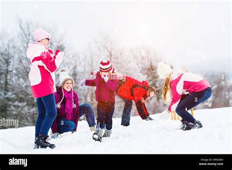 Family with kids having snowball fight in winter Stock Photo - Alamy