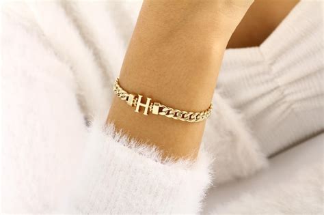 Premium Photo | A gold bracelet with a small chain that says h and h on it.