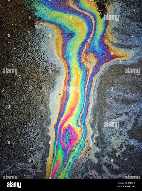 Rainbow oil puddle on the pavement Stock Photo - Alamy